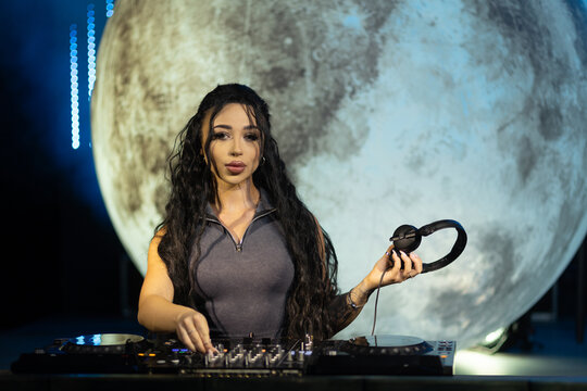 Female DJ Freestyling a Live Set with Moon Backdrop at Night