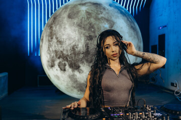 Female DJ Performing in a Club with a Moon-Themed Backdrop