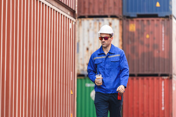 Engineer man walking at shipping yard, Warehouse dock worker work in cargo containers