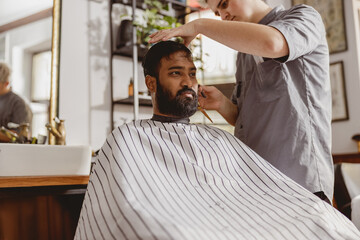 A highly skilled barber meticulously cutting a clients hair in a chic and stylish salon environment
