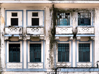 Obraz premium Old wooden windows and glass windows on a white abandoned building.