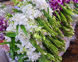 Bouquets of white Dendrobium orchid flowers for religious offerings on street vendor stall at Big...