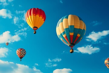 Naklejka premium Colorful Hot Air Balloons Soaring High - Freedom, adventure, exploration, serenity, joyful flight. Hot air balloons drift against a vibrant blue sky
