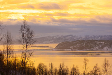 A beautiful landscape of a Norway fjord with snowy mountains during the arctic day. Arctic nature in Scandinavia during winter season.
