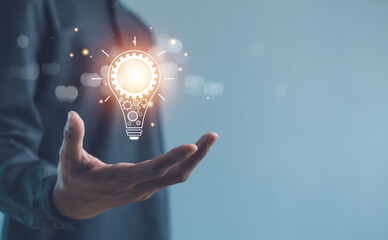 Hand of  holding illuminated light bulb, Idea innovation and inspiration concept.  creativity with bulbs that shine glitter, Concept for success. © paripat