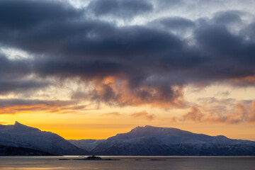 A beautiful small island in the Norway fjords during snowy winter day. Arctic nature in Scandinavia during winter season.
