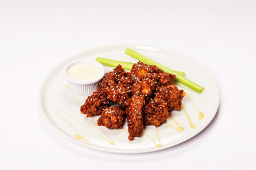 Korean BBQ Chicken Wings on white plate with blue cheese dip and celery