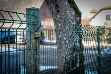 Damaged Metal Fence in a Snowy Urban Setting