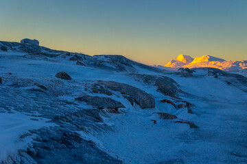 A beautiful, frozen, snowy winter day in the norwegian mountain pass. Arctic nature in Scandinavia during winter season.