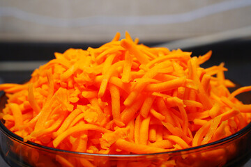 a large bowl of grated carrots. Cooking a vegetable salad from fresh vegetables. all-purpose grater.