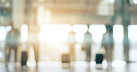 Blurred background, travel and business people in an airport with luggage for departure on an international flight. Flare, suitcase and an employee group walking in a terminal or lobby for boarding