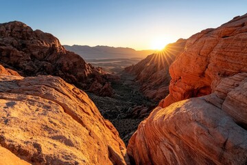 Obraz premium Massive red rock formations towering above a desert valley, warm golden sunset casting long shadows over the terrain