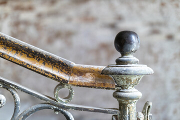 Close-up of a vintage metal and wood railing with a textured background, showcasing weathered...