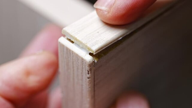the master glues the veneer edge, thin natural wood, came off the furniture. wear and tear of old furniture.
