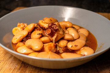 Delicious dish of large beans with octopus. Selective focus