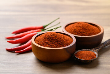 Red chili powder in bowl on wooden background, Food seasoning