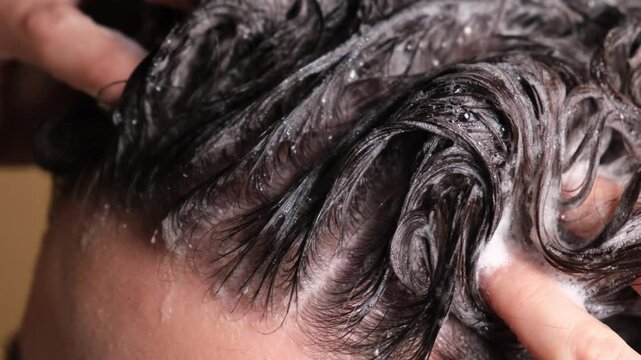 female hands or girl wash their hair with shampoo close-up