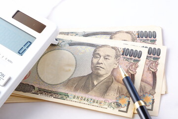 福沢諭吉の肖像の一万円紙幣と電卓
