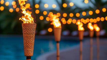 Tiki torches illuminate serene poolside setting with warm flames and bokeh lights
