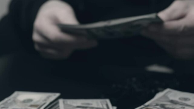 Bandit counts profits from robbery or extortion ,money, crime boss with a gun or other weapon