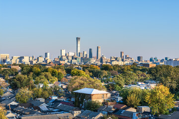 The scene of traditional dwellings coexisting with modern high-rise buildings in Chinese cities