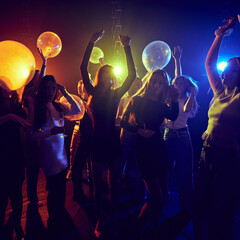 Group of young friends at a dynamic and festive party, celebrating birthday or holiday together, cheerfully dancing under neon lights. Concept of youth culture, party, fun and leisure © master1305