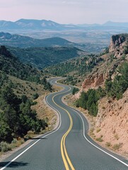 Curving two-lane road, bordered by rocks and arid landscape.
