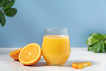 Orange juice or smoothie on blue background with copy space. Vitamin summer refreshing cocktail drink
