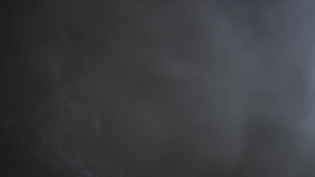 Black background and smoke. Lots of cigarette smoke. Suitable for effects in various videos. It's a pity for the environment. Stop smoking in public places. Thick white smoke on a black background.