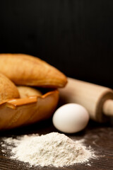 Homemade fresh bread with flour, egg and rolling pin on the table. Baking bread 
