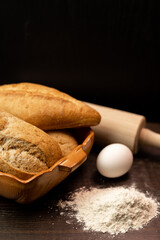 Homemade fresh bread with flour, egg and rolling pin on the table. Baking bread 