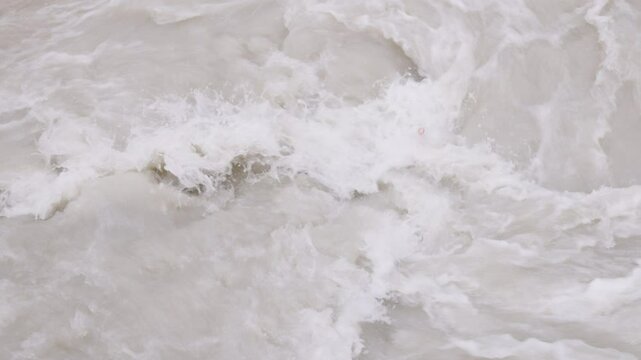 transparent plastic bottles trapped in muddy seething water in slow motion, closeup full-frame background