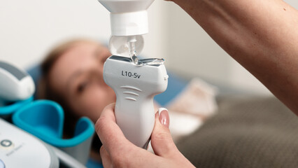 Close-up of a doctor's hands preparing an ultrasound probe before diagnosis. The concept of...
