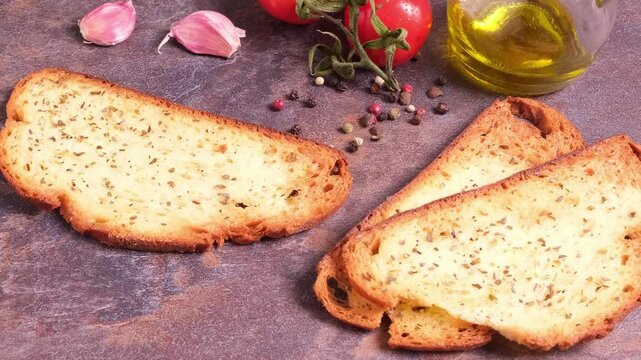 Fette di pane tostato e ingredienti per una bruschetta, aglio, pomodori, pepe, olio