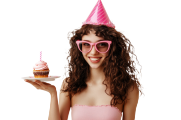 A lively and humorous young woman wearing pink glasses and a birthday hat, holding a cake on a plate with both hands, makes a wish with her eyes closed.