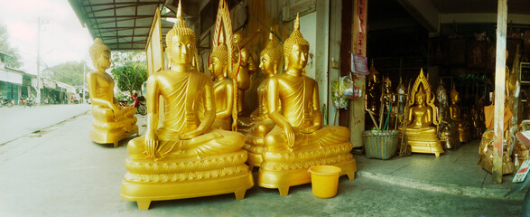 Panoramic view of gold statues of Buddha for sale at a market, Lopburi Province, Thailand.