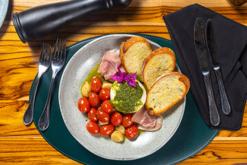 Salad with cherry tomatoes, bread, white cheese and ham