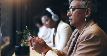 Face, phone and a business woman in a coffee shop while reading a text message for communication. Mobile, networking and cafe with a mature employee typing in a restaurant for a break from work