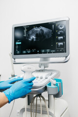 Close-up of a doctor's hands preparing an ultrasound probe before diagnosis. The concept of professionalism and precision in modern medical technology.