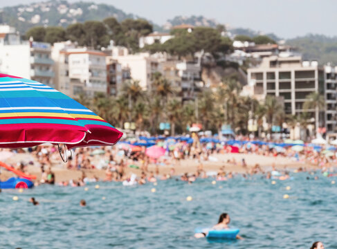 Colorful umbrellas brighten a busy beach on a sunny summer day