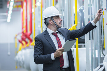 Professional engineer inspecting equipment in an industrial facility during work hours