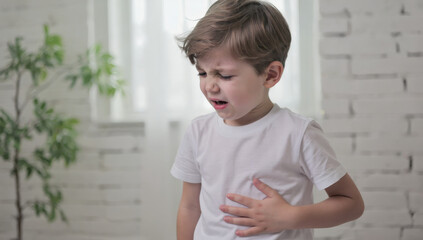 young boy experiences stomach pain, showing discomfort in bright room, Living with IBS Concept.
