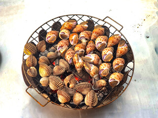 Fresh clams on the grill. Cooking with heat.