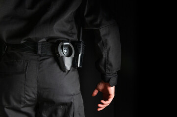 security guard controlling the premises. bodyguard in black uniform on black background, with...