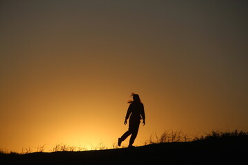silhueta de mulher em amanhecer na praia do cassino, rio grande do sul 
