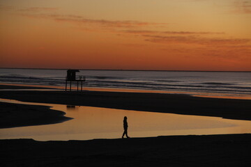 silhueta de mulher em amanhecer na praia do cassino, rio grande do sul 