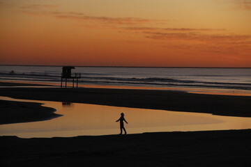 silhueta de mulher em amanhecer na praia do cassino, rio grande do sul 