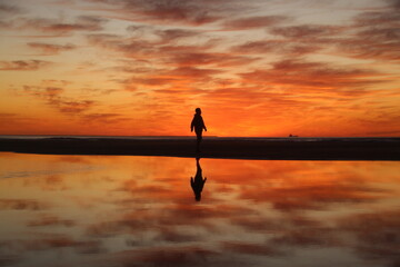 silhueta de homem em amanhecer na praia do cassino, rio grade do sul 
