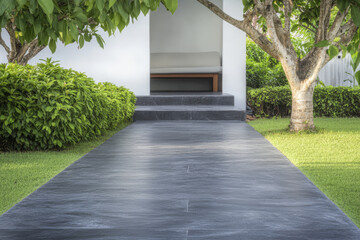 Naklejka premium Pathway leading to a serene outdoor seating area surrounded by lush greenery