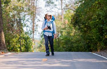 Fototapeta premium Senior woman is hiking outdoors, enjoying nature expression looks into the distance observing and possibly guide trekking and trail ecotourism adventure concept.